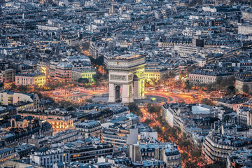 Aerial view of the Arc de Triomphe de l'Etoile (The Triumphal Arch) in Paris at sunset with traffic...