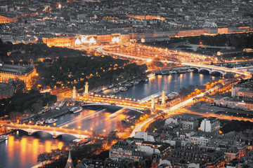 Aerial view of famous bridges in Paris at night. Seine river with traffic lights in Paris, France.