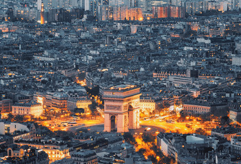 Aerial view of the Arc de Triomphe de l'Etoile (The Triumphal Arch) in Paris at sunset with traffic lights. - obrazy, fototapety, plakaty