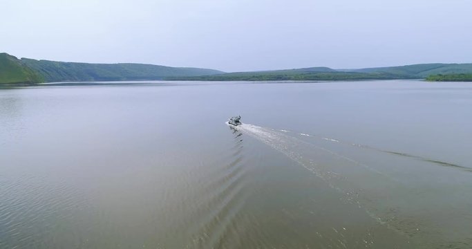 Circular footage of little modern boat in the river. Shot from above taken by drone. Outdoors. Summertime. Nature, flying, camera, landmark, outdoors, outside