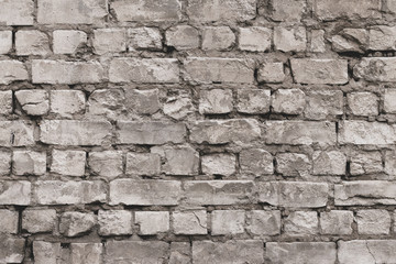 Vintage grey brick wall texture. White old cement wall background. Pattern with gray dilapidated bricks. Blank concrete grunge wall for decoration design. Grey bricks surface. Empty space.