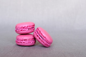 Stack of delicious french purple blueberry macarons on grey background