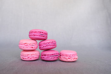 Obraz na płótnie Canvas Stack of delicious french strawberry and bilberry macarons on grey background