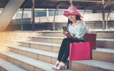 Beautiful woman with shopping bag Telephone on the overpass