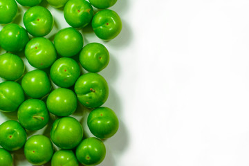 Pile of green plum fruit isolated on white