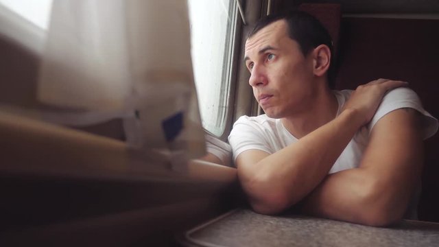 man sad bored riding a train railway looks out the window. traveler concept train railroad journey travel. slow motion video. beautiful from window of a moving lifestyle train railway trip Russia