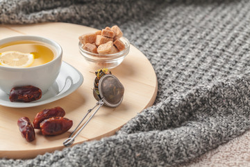 Top view of a cup of tea with lemon piece on wooden table