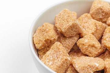 Brown cane sugar cubes isolated on white background