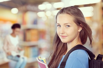Young smiling woman holding blue notebook