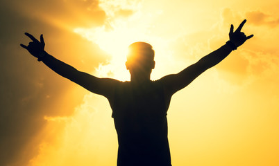 silhouette of man with open arms raised