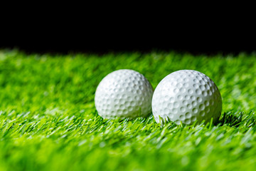 Golf ball on grass in black background