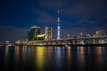 View of the Skytree Tower with the reflection in the river at night. Landscape orientation.