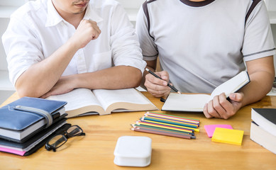 High school tutor or college student group sitting at desk in library studying and reading, doing homework and lesson practice preparing exam to entrance, education, teaching, learning concept