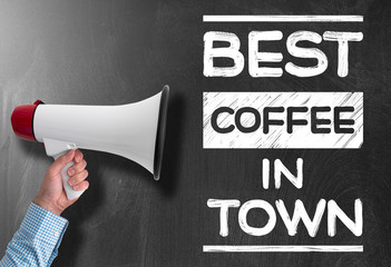 hand holding megaphone or bullhorn against blackboard with text BEST COFFEE IN TOWN