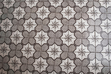 Geometric pattern on the black and white parquet floor. eight-pointed stars, squares, crosses and lines. gray texture, background