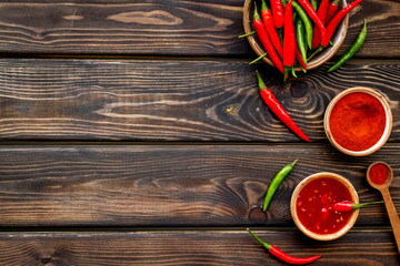 Fresh and powdered red and green chilli pepper pattern on wooden table background top view space for text