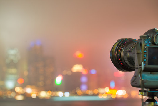 Camera on tripod making automatic pictures of amazing city skyline at night. Skyscrapers lights