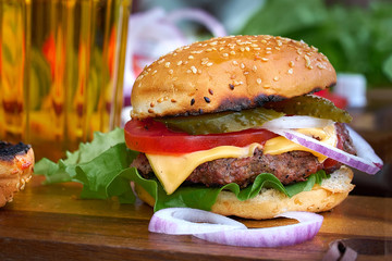 Tasty big burger and beer glass on wood table