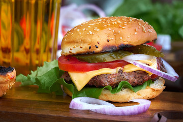 Tasty big burger and beer glass on wood table