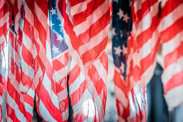 Detail and close up shot of waving american flags. Rippled red and white stripes, patriotism and national pride concept. Natural daylight, warm and cool color tones. 