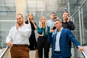 Obraz premium young beautiful people men and women at work call by phone
