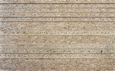 Fototapeta premium Chipboard background. Rough plywood texture. Plate of compressed sawdust.
