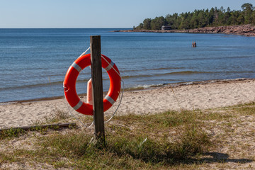 Lifebuoy on the sandy Degersand beach on the Baltic Sea, Aland islands, Finland