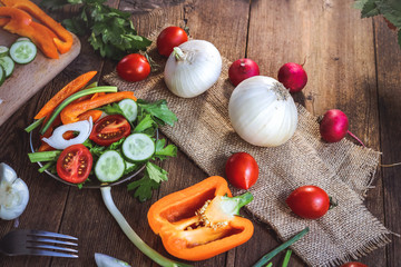 fresh vegetable salad - sweet peppers, tomatoes, cucumbers, celery. on a wooden board.