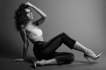 Young beautiful woman with curly hair posing in black and white