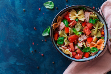 Italian salad with pasta ham and vegetables blue background