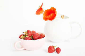 healthy eating, strawberries in a cup next to a teapot on a white background, vegetarian and vegan food, ecological products