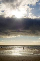 silhouette of people walking on beach