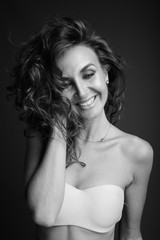 Naklejka premium Young beautiful woman with curly hair posing in black and white