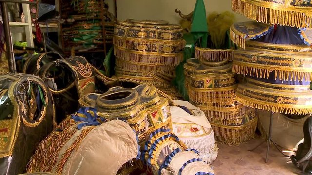 Close-up low-angle tilting shot of cultural masks and costumes on display at a shop in Oruro City, Bolivia.