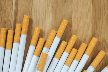 image of several commercially made cigarettes. pile cigarette on wooden. or Non smoking campaign concept, tobacco. top view.