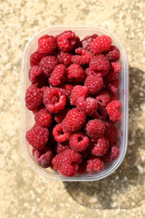Package full of freshly picked raspberries. Top view.