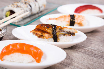 four kinds Nigirisushi on oval saucers and Uramaki