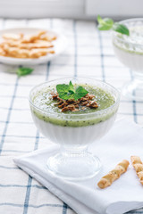Milk dessert with kiwi. Pana cotta with green kiwi jelly in glass bowls. Sweet breakfast in bright colors.