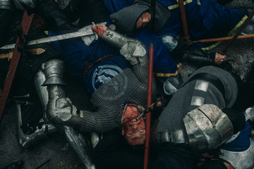The murdered medieval knights crusaders lie on the battlefield.