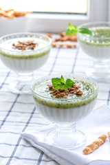 Milk dessert with kiwi. Pana cotta with green kiwi jelly in glass bowls. Sweet breakfast in bright colors.