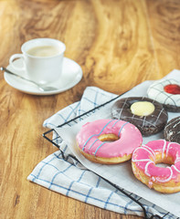 Donuts and coffee on wooden table.
