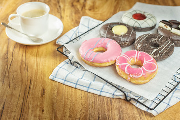 Donuts and coffee on wooden table.
