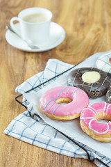 Donuts and coffee on wooden table.