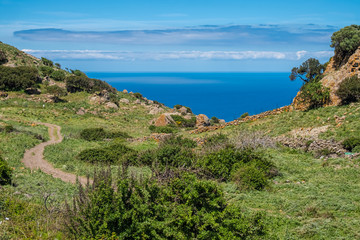 Spectacular landscapes, awe-inspiring cliffs, charming villages and historical landmarks along the coastal road between Alghero and Bossa (SP 105), Sardinia, Italy. 