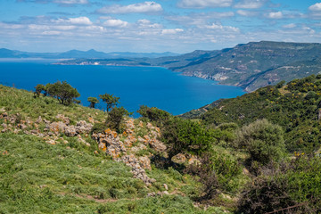 Fototapeta na wymiar Spectacular landscapes, awe-inspiring cliffs, charming villages and historical landmarks along the coastal road between Alghero and Bossa (SP 105), Sardinia, Italy.