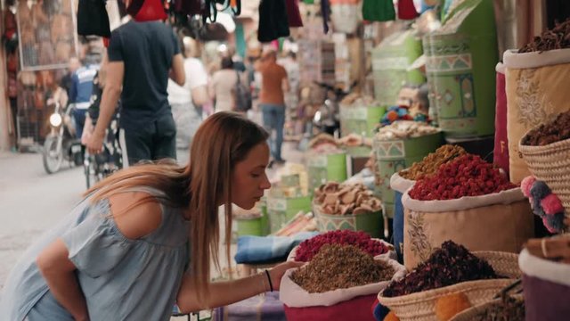 Woman walking on MAROCCAN MARRAKECH spices market. Woman walking on beautiful african arabian spices market and choose spices, travel tourist