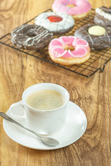 Coffee and donuts on wooden table.