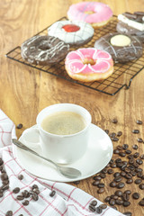 Coffee and donuts on wooden table.