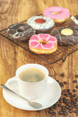 Coffee and donuts on wooden table.