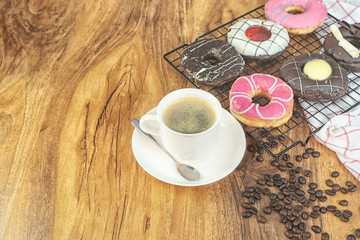 Coffee and donuts on wooden table.